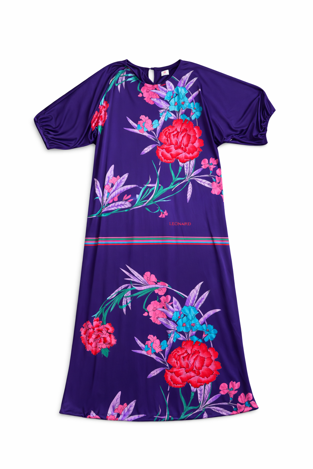 A stunning vintage hostess dress by iconic French fashion house Leonard Paris, dating to the 1970s. Leonard became world-famous for its vibrant printed silk jersey dresses, beloved for their luxurious comfort and bold botanical patterns.

This piece features a dramatic deep purple ground adorned with oversized floral motifs in vivid reds, pinks, and turquoise. The relaxed silhouette and fluid silk jersey fabric create the effortless elegance Leonard is known for.

Originally designed as a “hostess dress,” t