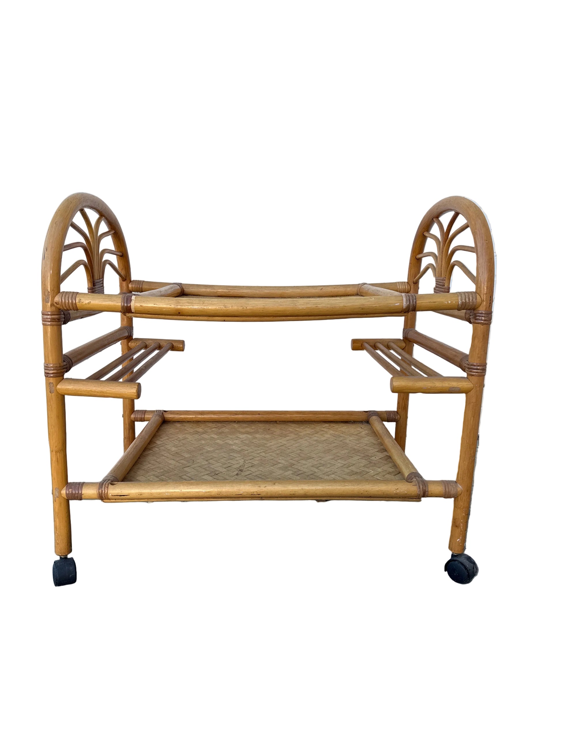 Rattan bar cart against a tiled wall and concrete floor.