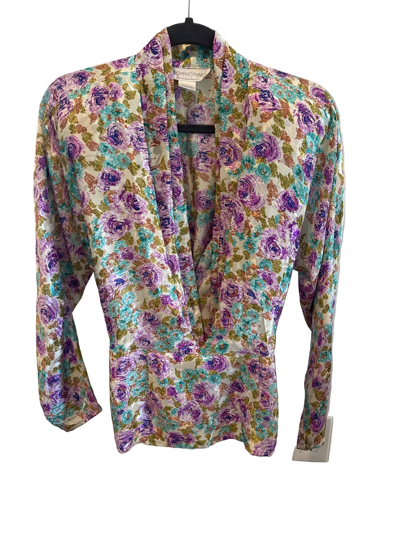 Floral-patterned shirt on a hanger against a white background